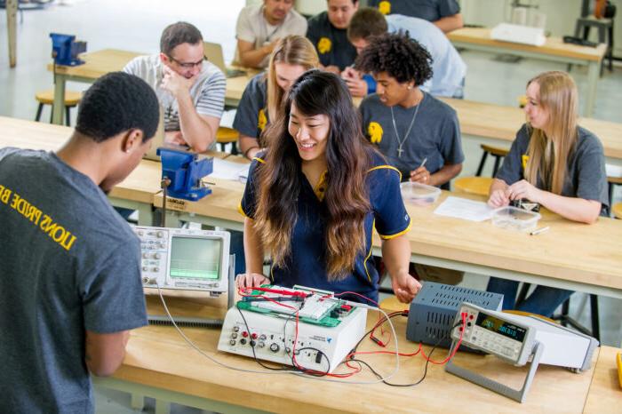 Science and Engineering students working on a circuit board.